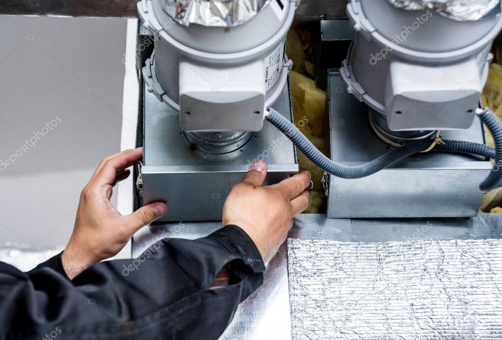 Techniker prüft eine Lüftungsanlage im Technikraum