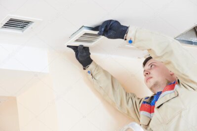 Servicetechniker wechselt Luftfilter einer Lüftungsanlage