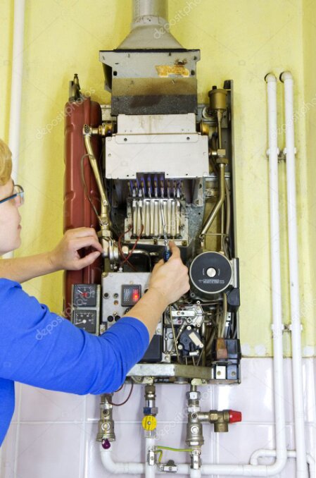 Heizungsmonteur arbeitet an einer Heizungsanlage
